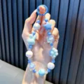 Handmade light blue beaded phone charm featuring cute rabbit and pearly star pendants - Blue