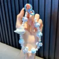 Charmante blauw-witte kralen telefoonriem met iriserende vliegtuighanger voor meisjes - Blauw