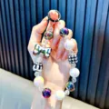 Colorful Y2K beaded phone strap featuring iridescent charms, bow, and a black clip hanger - Black