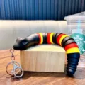 Portachiavi a serpente articolato in nero con anelli rossi e gialli e faccia sorridente - Nero