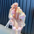 Handmade colorful beaded phone charm featuring a pink pixel heart and flower charms - Pink
