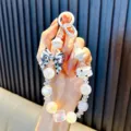 Dragonne de téléphone perlée colorée avec perles irisées et un nœud noir et blanc élégant - Style Nœud Carré Blanc