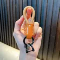 Hand hält geflochtenen PU-Leder-Schlüsselanhänger mit braunem Patch und D-Ring - Khaki