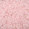Detailed macro view of light pink imitation jade round seed beads for DIY jewelry - Pink