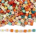 Detailed view of colorful square acrylic alphabet beads with golden letters for DIY - Solid Color + Gold Font