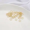 Primer plano de anillas retorcidas bañadas en oro de 14K para joyería artesanal DIY. - Juego de 20 Piezas / Diámetro 6mm / Lleno de Oro 14K