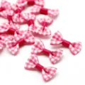 Close-up macro view of small pink and white gingham fabric bows for DIY hair accessories - Rose Red