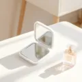 Minimalist white double-sided folding makeup mirror on a clean white desk surface - 5.5*6cm / White