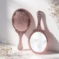 Elegant rose gold handheld vanity mirror with vintage embossed floral pattern detail - 10.5x24.6cm / Champagne Gold