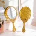 Elegant gold handheld vanity mirror featuring an ornate floral pattern engraving on the back - S / Gold