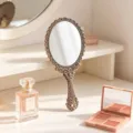 Vintage handheld makeup mirror with intricate floral antique pattern in gold finish - S / Bronze