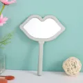 Close-up of a unique lip-shaped handheld makeup mirror in a minimalist aesthetic setting - Without Pattern / 12*16cm / Green
