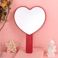 Red heart-shaped handheld makeup mirror for portable vanity use on pink background - 13cm*18cm / Red