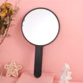 Large round handheld makeup mirror with a matte black handle on a pink background - 12cm*21cm / Black
