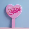 Pink heart-shaped handheld makeup mirror with decorative Pink Bubble text detail. - 12.5cm*18cm / Pink Text