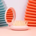 Portable pink folding mirror with integrated air cushion massage hair brush for travel. - 7*7.5cm / Pink
