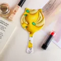 Süßer katzenförmiger Handspiegel mit lebhaftem gelbem Bananenmuster-Aufdruck - Katzenohr Form Handspiegel / Gelbe Bananenmilch