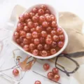 Detailed macro view of coral orange iridescent AB acrylic bubble beads in heart-shaped bowl - 8mm (50pcs/pack) / Red