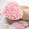 Close-up of pink acrylic crackle bubble beads in a heart bowl for DIY jewelry - 8mm (50pcs/pack) / Pink