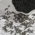Vista macro dettagliata di perline di vetro grigio scuro trasparenti per artigianato DIY - Grigio Scuro (2mm) / Confezione da 15g (circa 1000 pezzi) / Grigio nero