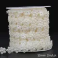 Close-up view of cream white ABS faux pearl flower trim chain on a white spool - Floral / 13mm 2m Pack / Beige
