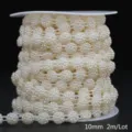 Detailed view of 10mm off-white ABS faux pearl chain on a spool, total 2m length. - Floral / 10mm 2m Pack / Beige