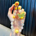 Handgefertigte bunte Perlen-Handykette mit gelber Schleife und schillernden Perlen - Mit Handy-Pad / Gelb