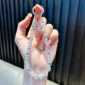 Dragonne de téléphone en cristal irisé avec un fermoir en anneau métallique argenté - Blanc