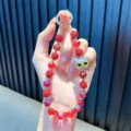 Dragonne de téléphone en perles rouges avec un pendentif tête de chat argenté étincelant. - Rouge