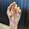Funkelndes perlenbesetztes Handyband mit rotem Schmetterling und rosa Glitzerperlen. - Legierung Strass Schmetterling / Inklusive Dichtung / Rosa