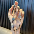 Funkelnde Kristall-Handykette mit schillernden Perlen und blauem Schmetterlingsanhänger - Legierung Strass Schmetterling / Inklusive Dichtung / Schwarz