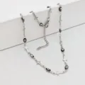 Detailed view of stainless steel cross necklace featuring black and white evil eye beads - 42+5cm / Black Oval Evil Eye & Cross