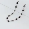 Detail view of stainless steel necklace with multiple black evil eye beads on silver chain - Black