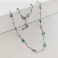 Detailed view of stainless steel cross and green enamel evil eye charms on a silver chain. - 42+5cm / Emerald Square Evil Eye & Cross