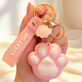 Detailopname van een schattige roze kattenpoot sleutelhanger met Lucky Day polsbandje - Roze Kattenpoot