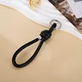 Schwarzes geflochtenes Leder-Handgelenkband für Handy oder Tasche mit silbernem Verschluss - Charm-Anhänger / Römischer Knoten Silberperlen-Anhänger (K6008) / Schwarz