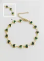 Detail view of heart-shaped green crystal charms on a gold stainless steel anklet chain. - Dark Green
