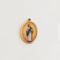 Detailweergave van een ovale roestvrijstalen hanger met een kleurrijke Sint Judas figuur. - Goud