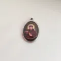 Detailopname van ovale roestvrijstalen hanger met vintage religieus heiligenportret - Staalkleur