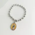 Dettaglio di bracciale a perle in acciaio inox con ciondolo a medaglia religiosa - Ritratto di San Giuda