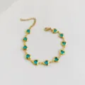 Detailed view of a gold stainless steel bracelet featuring blue heart-shaped crystals. - Sky Blue