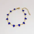 Dettaglio di un bracciale in acciaio inossidabile dorato con cuori in vetro blu - 17+5cm / Blu