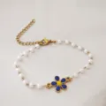 Vista dettagliata del bracciale in perle di acciaio inossidabile dorato con margherita - Colore acciaio / Blu
