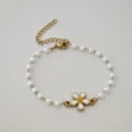 Detail shot of gold stainless steel daisy bracelet with white imitation pearls - White
