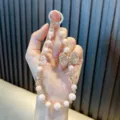 Elegant beaded phone wrist strap featuring pearls and a sparkling rhinestone bow charm detail. - 1 Piece/Pack (With Gasket) / Champagne