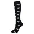 Gros plan sur des chaussettes de compression noires à motif cœur blanc genou - Motif Cœur Noir