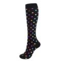 Gros plan d'une chaussette de compression noire ornée d'un motif à pois colorés éclatants. - Noir avec des points colorés