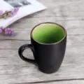 Matte black ceramic mug with vibrant green interior and rounded handle - Green