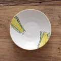 Bol en céramique japonais peint à la main avec motifs de maïs sur une table en bois. - Motif de Maïs / Assiette Ronde de 7 Pouces