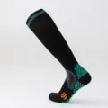 Close-up of black sports compression calf socks with green non-slip grip patterns. - S/M / Black